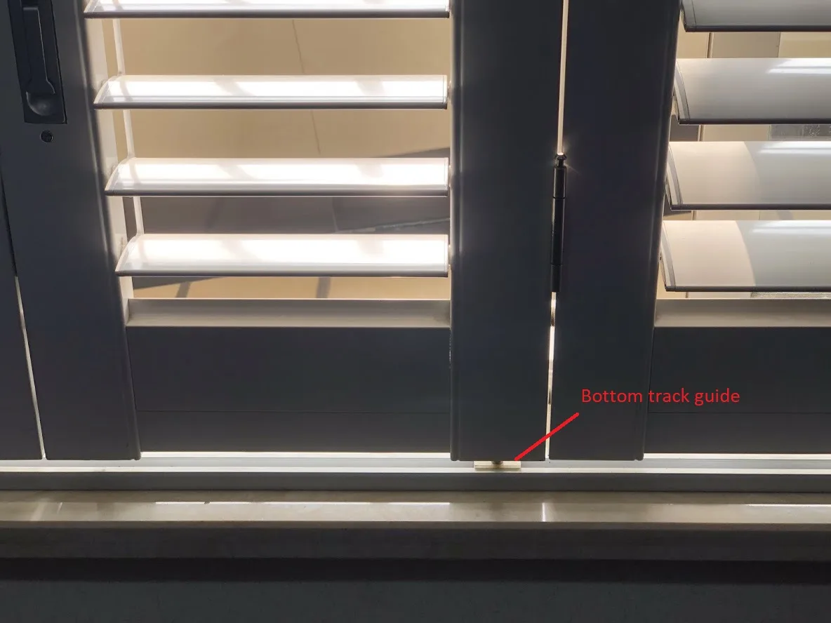 Bottom track with pivot and guide hardware for bi-fold aluminium shutters